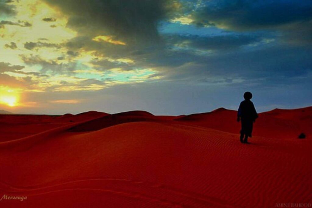 Dunes dorées du désert du Maroc à Merzouga avec caravane de chameaux au coucher du soleil