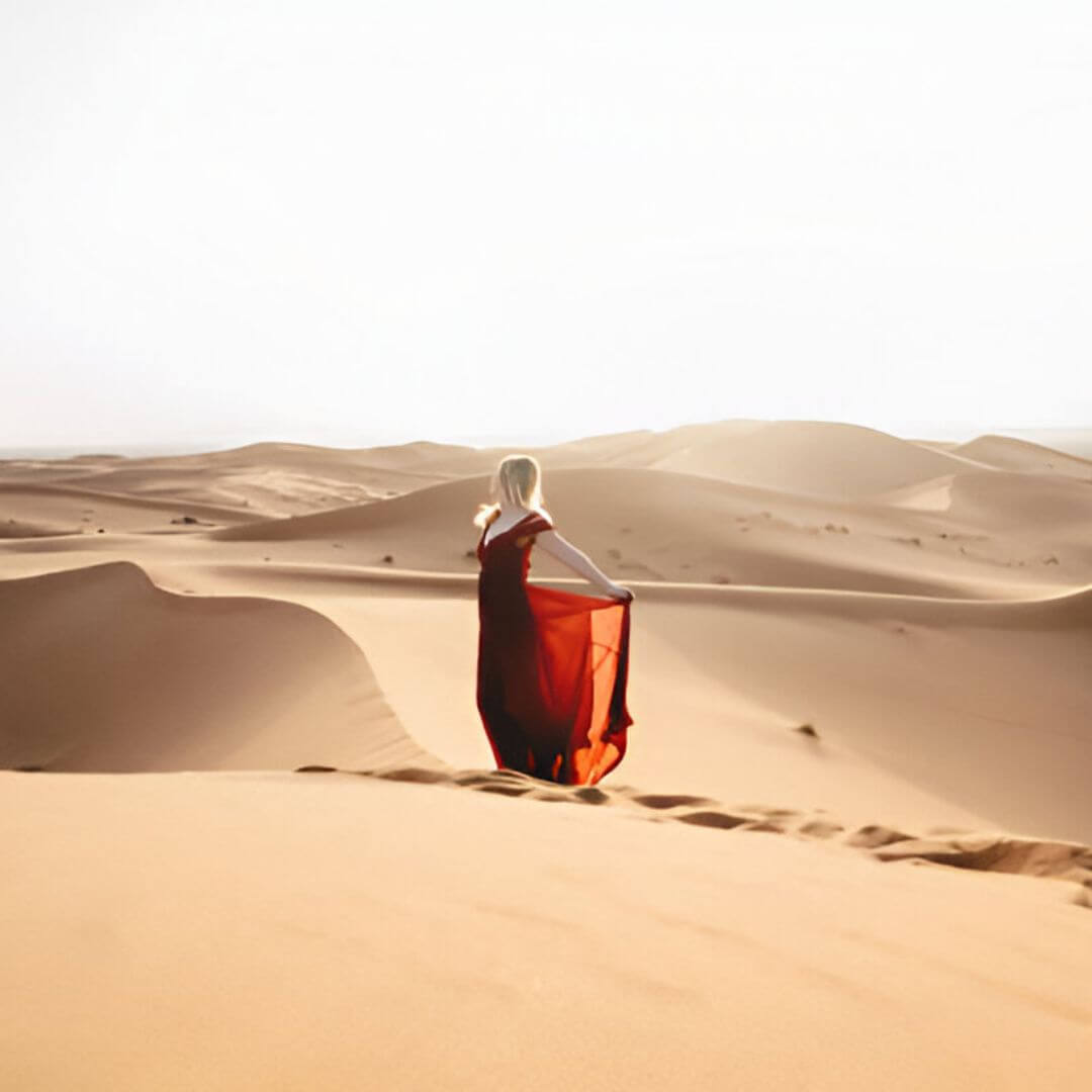 Fille-jouant-dans-le-sable-pres-des-tentes-du-camping-a-Merzouga.jpg