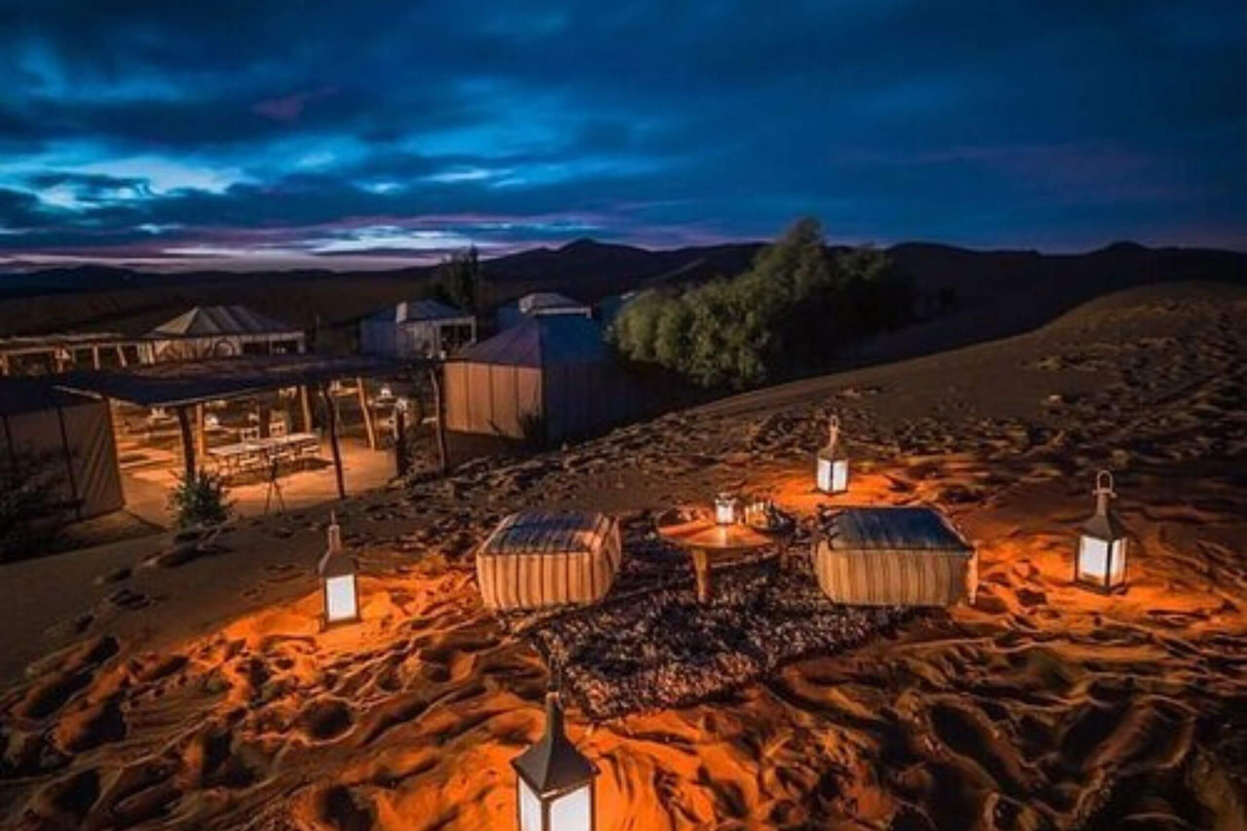 Nuit claire dans le désert de Merzouga avec tente berbère et ciel étoilé en arrière-plan