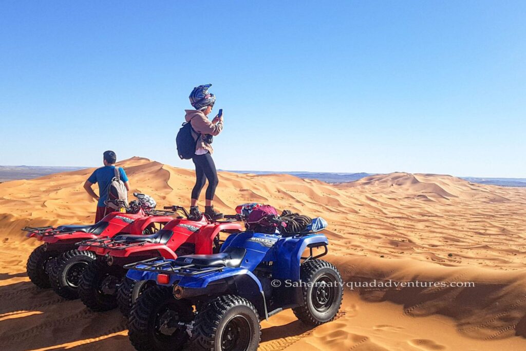 Quad tout-terrain traversant les dunes de sable à Merzouga