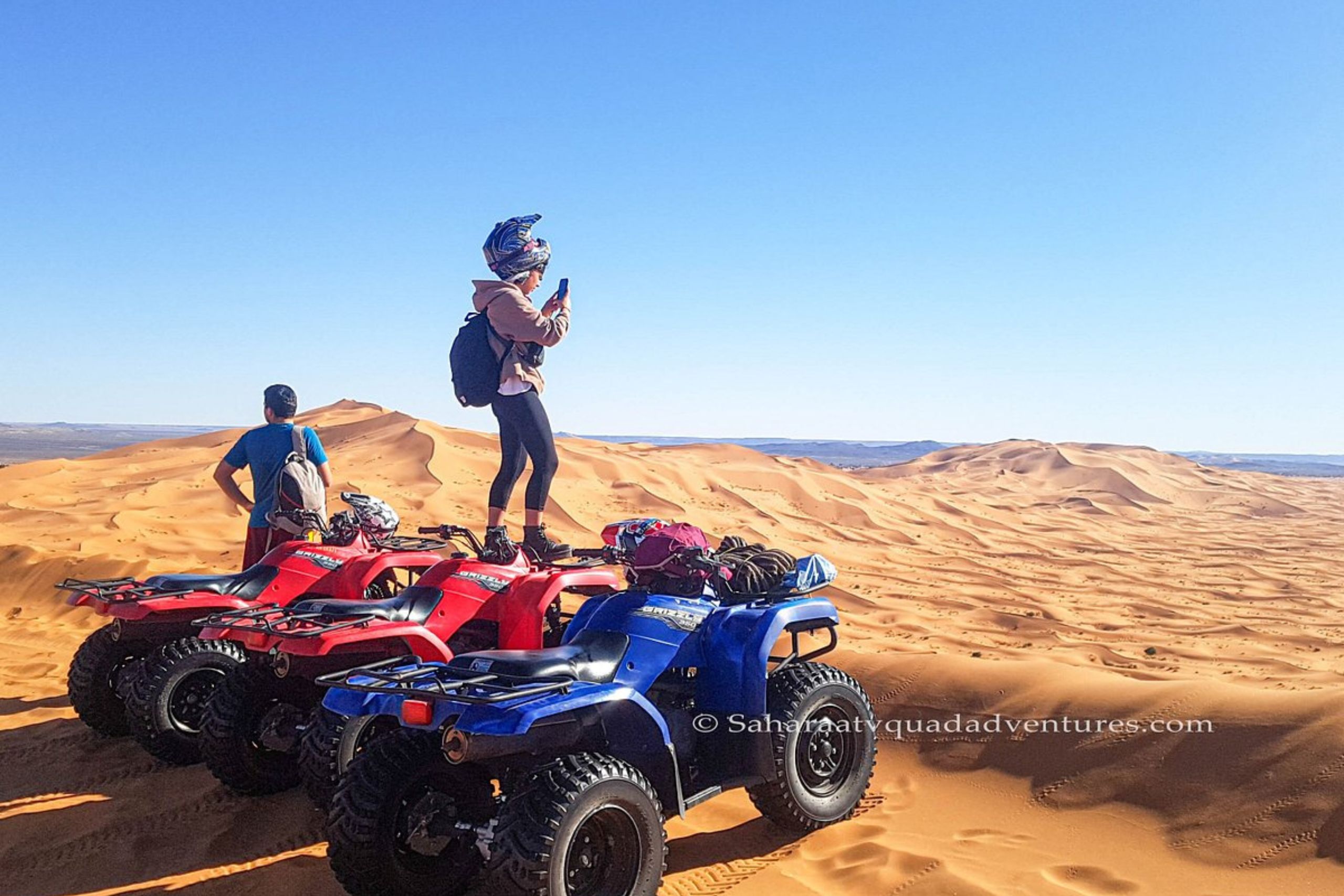 Quad tout-terrain traversant les dunes de sable à Merzouga
