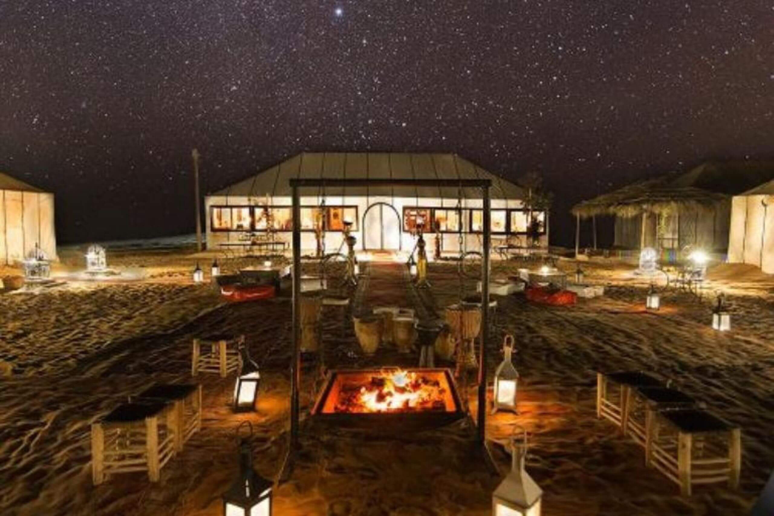 Tente berbère traditionnelle illuminée sous un ciel étoilé dans le désert de Merzouga