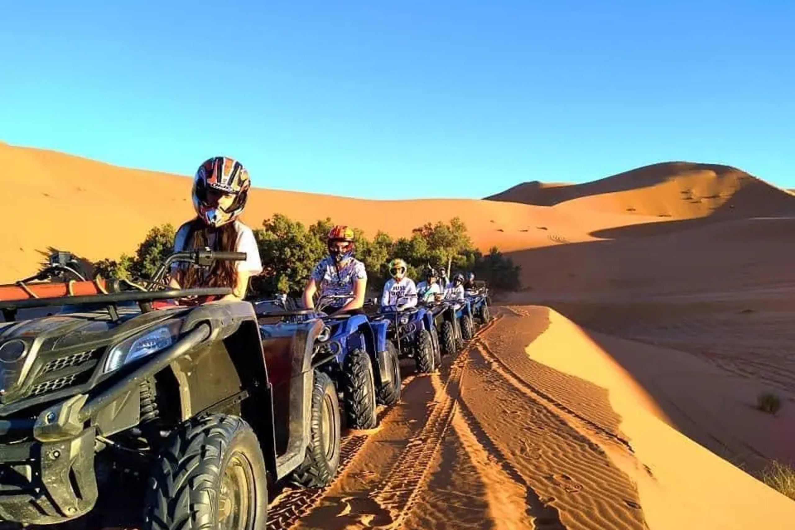 Touriste en quad explorant le désert de Merzouga au coucher du soleil