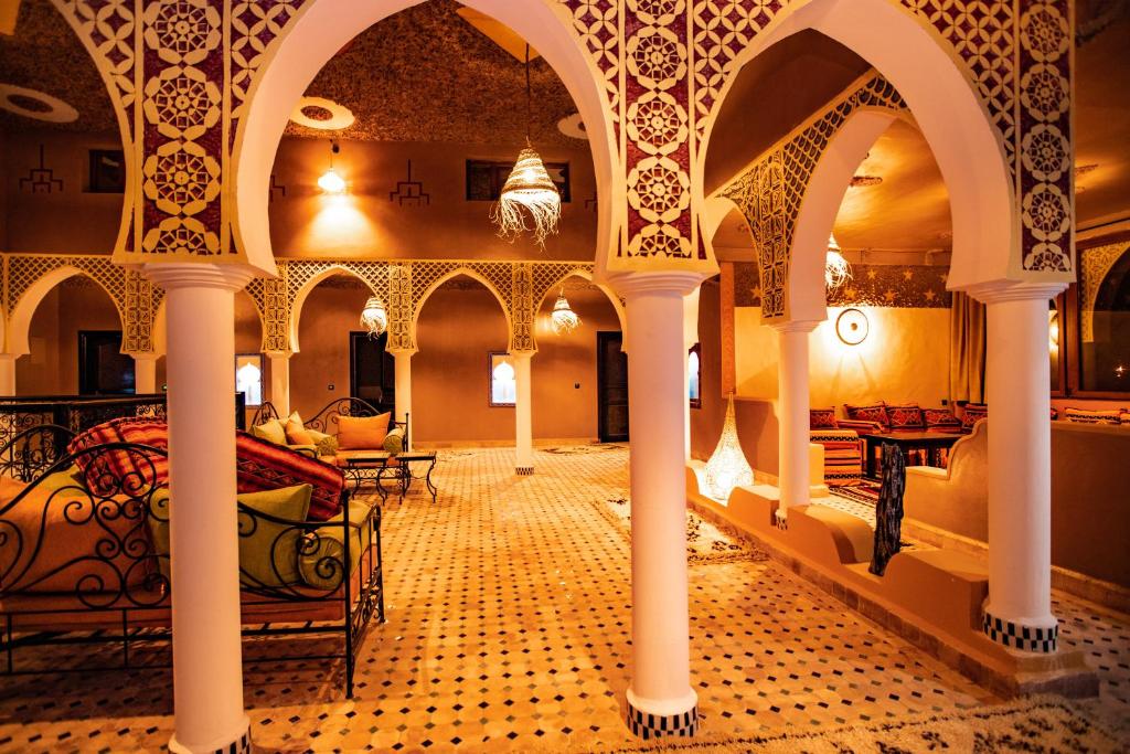 Cour intérieure authentique d'un riad à Merzouga avec fontaine centrale, tapis berbères et lanternes traditionnelles en métal ouvragé