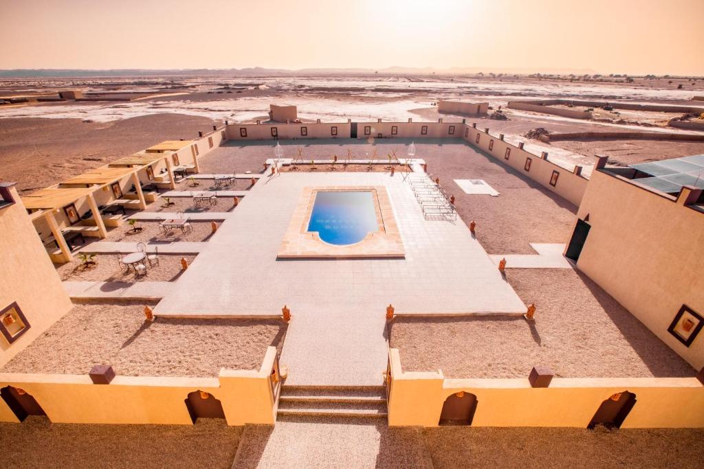 Terrasse sur le toit d'un riad Merzouga avec transats et vue imprenable sur les dunes d'Erg Chebbi et le paysage désertique marocain